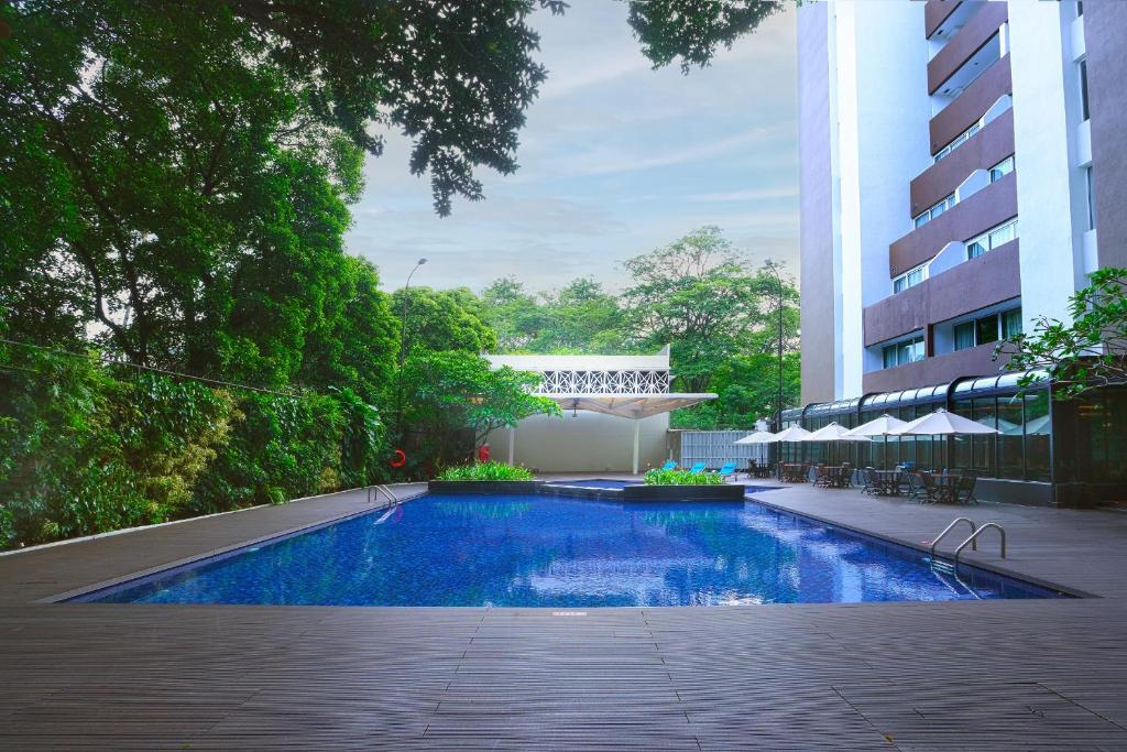 a swimming pool in front of a building at Swiss-Belhotel Pondok Indah in Jakarta
