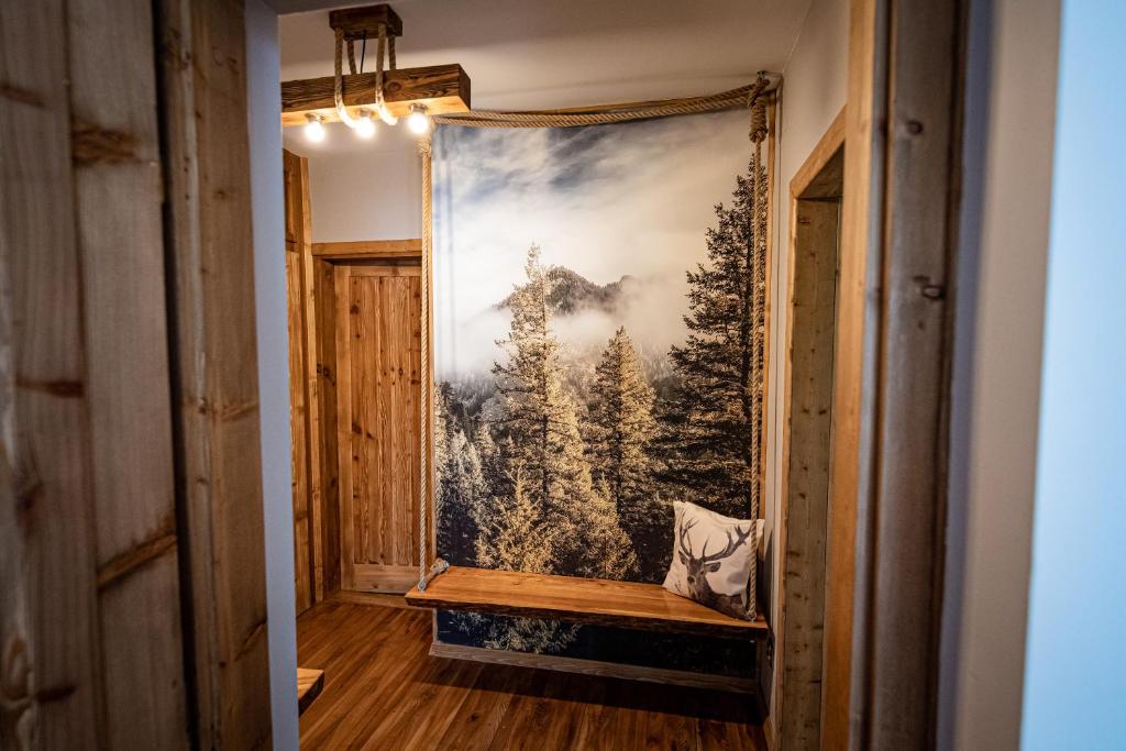 a tapestry hanging in a hallway with a bench at Zacisze Pod Reglami in Zakopane