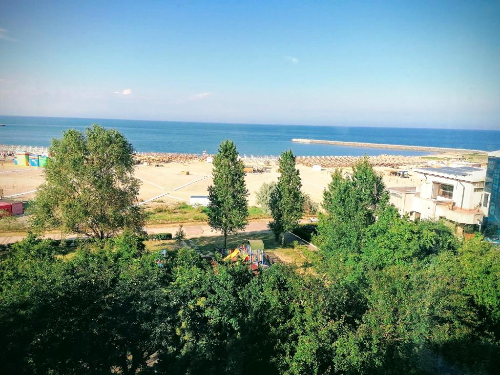 a view of a beach with trees and the ocean at Selens Residence in Constanţa