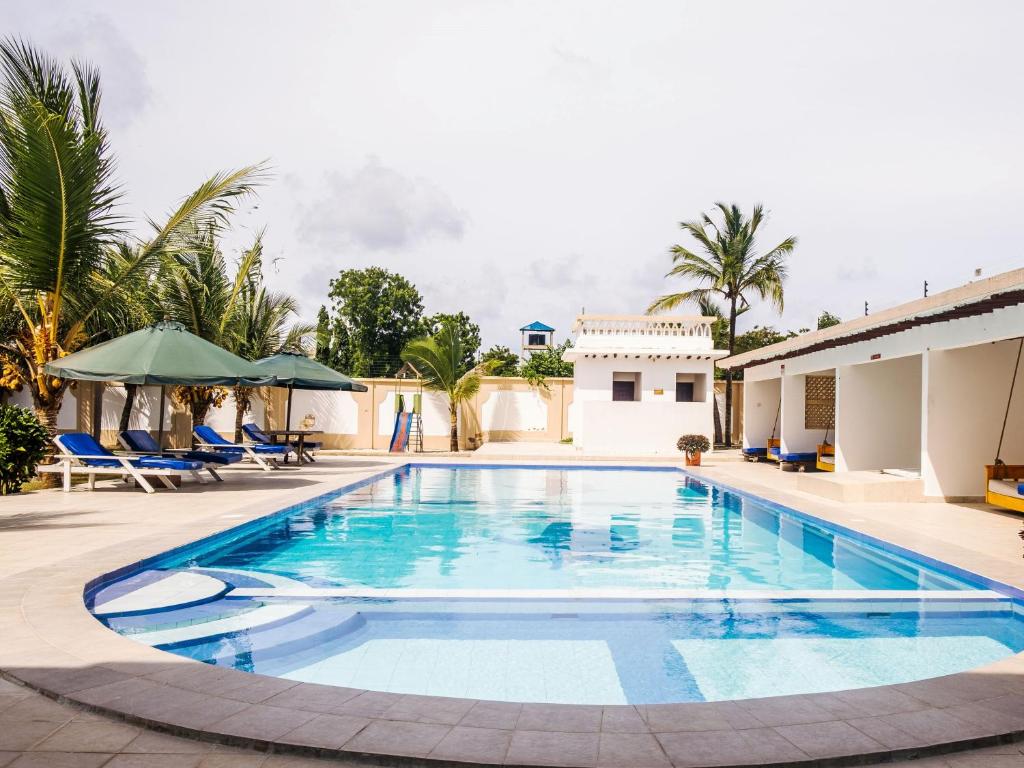 a swimming pool at a villa with a resort at Uhai Vacations in Diani Beach