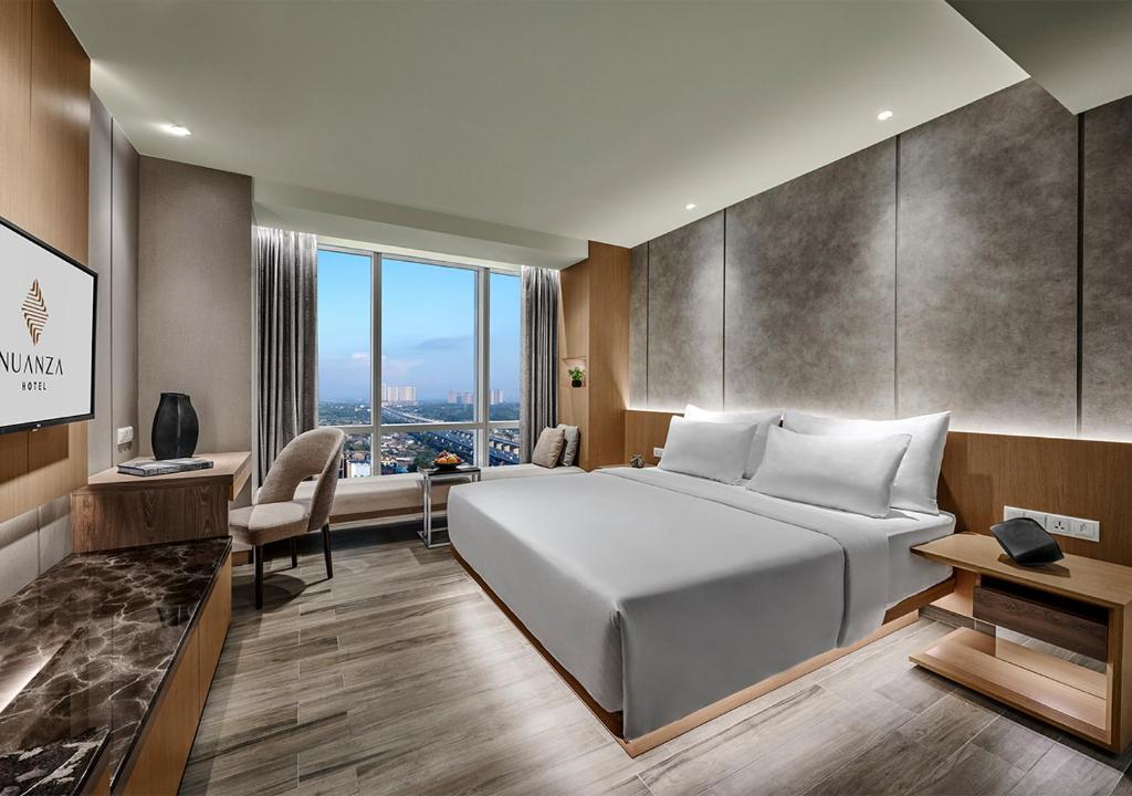 Un pat sau paturi într-o cameră la Nuanza Hotel & Convention Cikarang