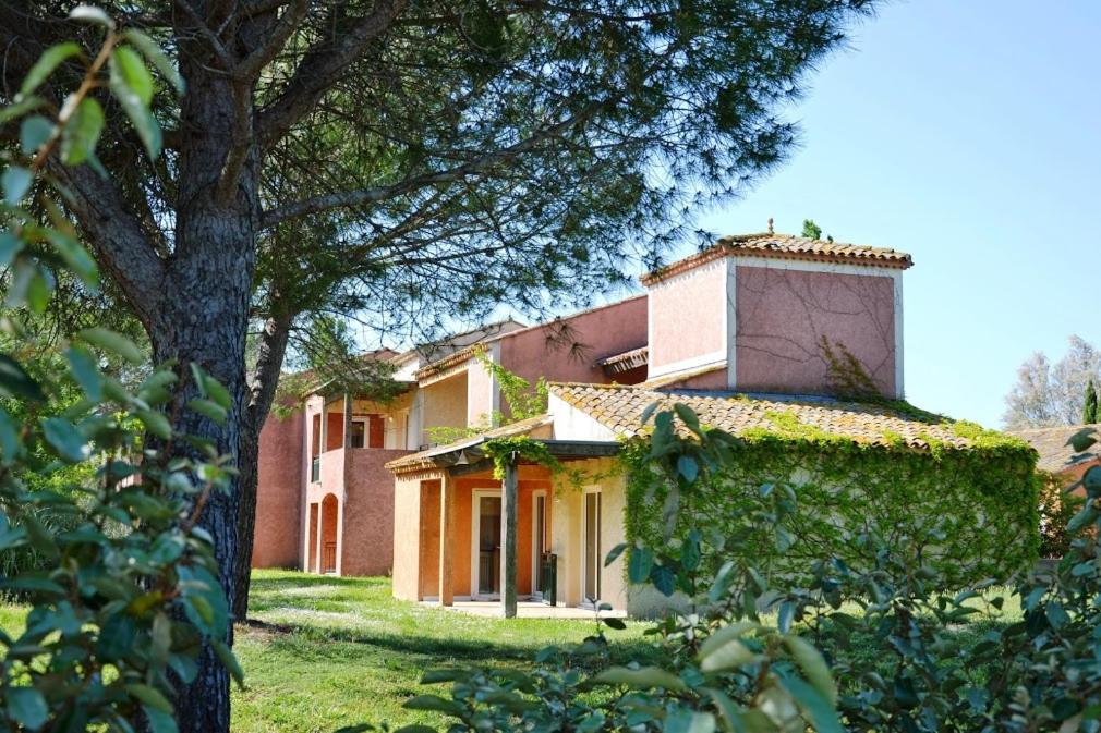 una casa con un albero e un edificio di SOWELL RESIDENCES Les Hameaux de Camargue a Arles