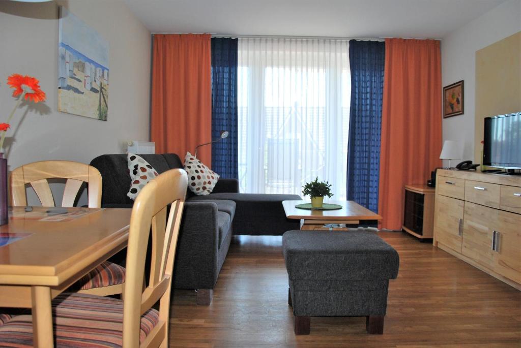 uma sala de estar com um sofá e uma mesa em Haus am Mühlenpark Whg. 4 em Cuxhaven