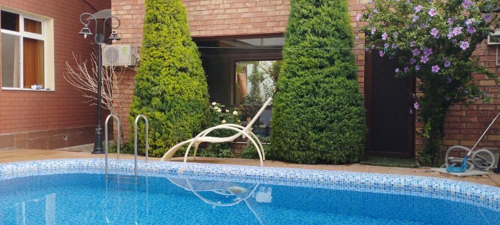 - une piscine avec une chaise à côté d'une maison dans l'établissement Green House ECO HOTEL, à Samarcande