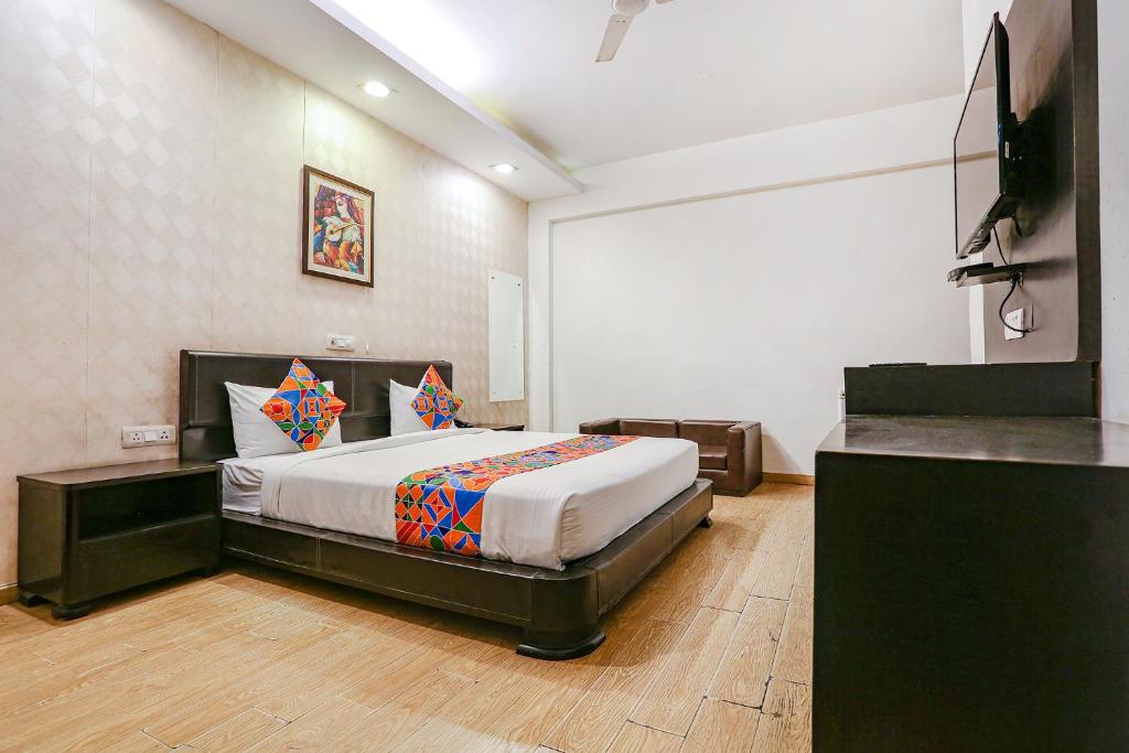 a bedroom with a bed and a flat screen tv at FabHotel Premium Nest in Gurgaon