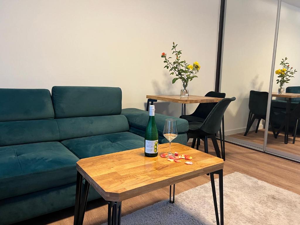 salon z zieloną kanapą i butelką wina na stole w obiekcie Last Pub Rynek-Klima-ParkigFree-Netflix-YouTube we Wrocławiu