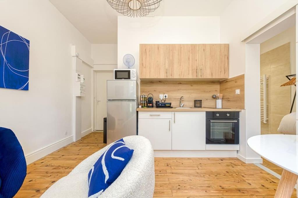 a kitchen with a refrigerator and a table in a room at 2 pièces tout confort, déco moderne, wifi fibre in Grenoble