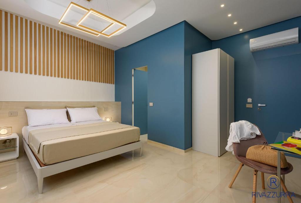 a bedroom with a bed and a blue wall at Rivazzurra Beach Rooms in San Vito lo Capo