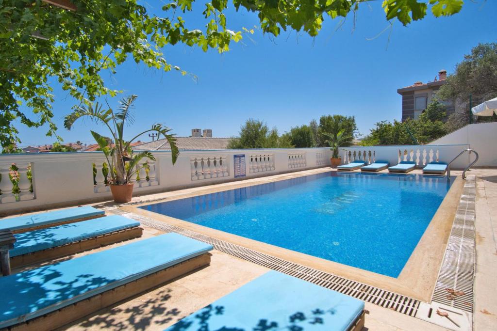 une piscine avec des chaises longues dans une cour arrière dans l'établissement İonic Alaçatı, à Çeşme
