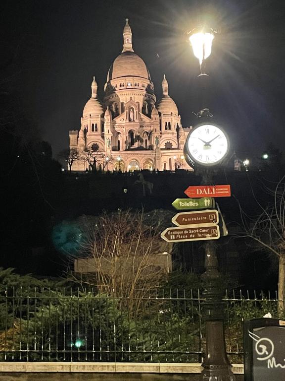 um grande edifício com um relógio em frente em Montmartre sacré cœur em Paris
