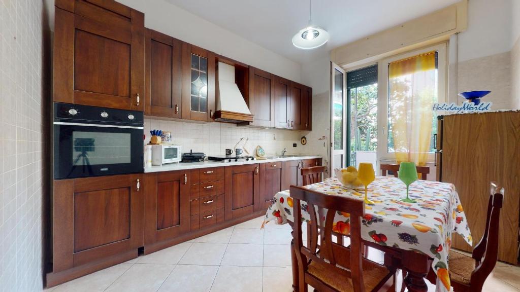 a kitchen with wooden cabinets and a table with a dining room at House Antica Romana by Holiday World in Genoa