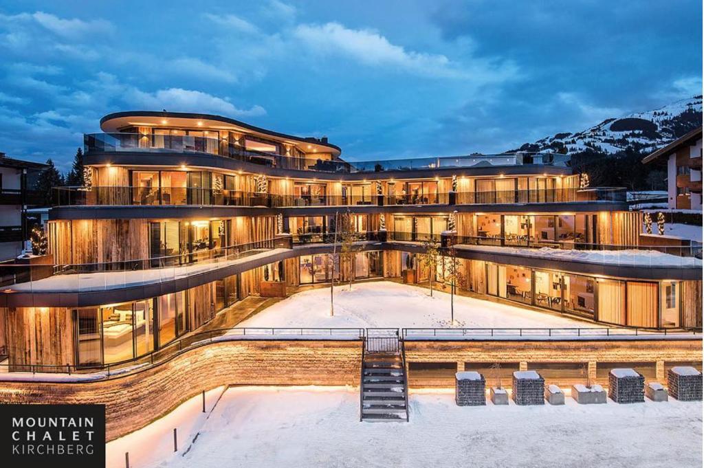 a large building in the snow at night at Mountain Chalet Kirchberg by Apartment Managers in Kirchberg in Tirol