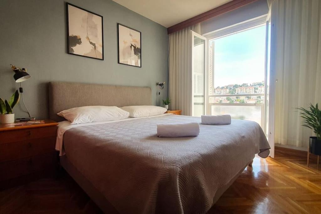 una camera da letto con un grande letto con due asciugamani di Apartment Carrington a Dubrovnik