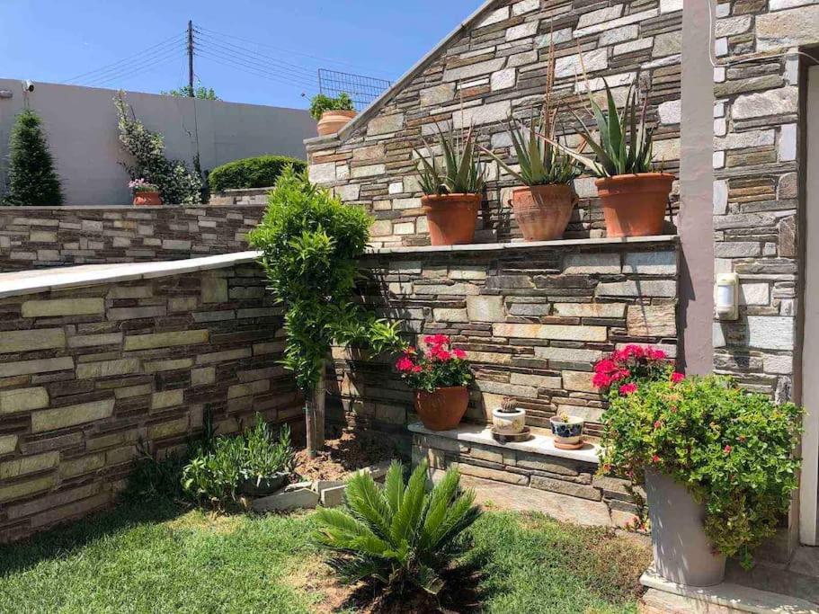 a brick retaining wall with potted plants on it at Villa Casa Chrissy in Plagiárion
