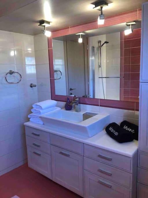 a bathroom with a sink and a large mirror at Villa Casa Chrissy in Plagiárion