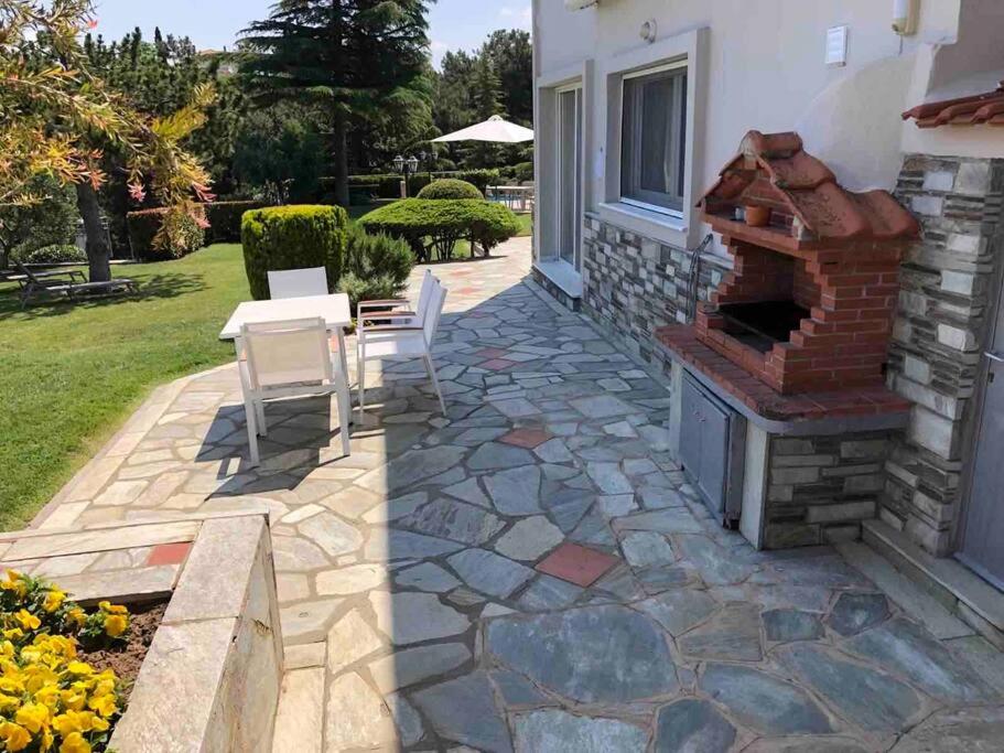 a patio with a brick oven and a table and chairs at Villa Casa Chrissy in Plagiárion