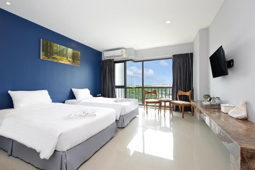 1 dormitorio con 2 camas y pared azul en VST Residence -SHA PLUS Certified en Ban Khlong Bang Ping