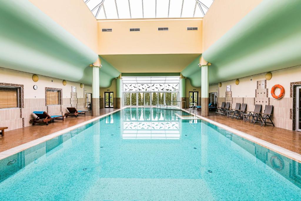 einem großen Pool in einem Gebäude mit einer Decke in der Unterkunft Hotel Savannah in Chvalovice