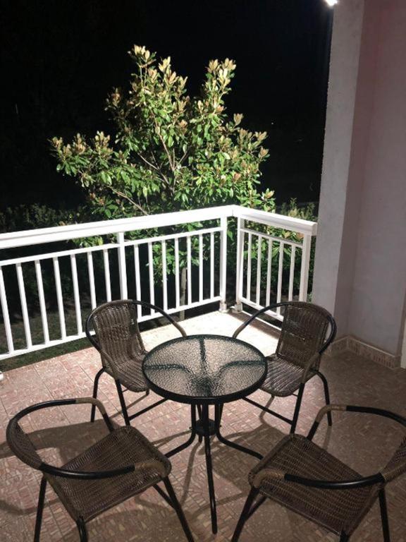 a table and chairs on a balcony at night at Villa Predlug in Čapljina
