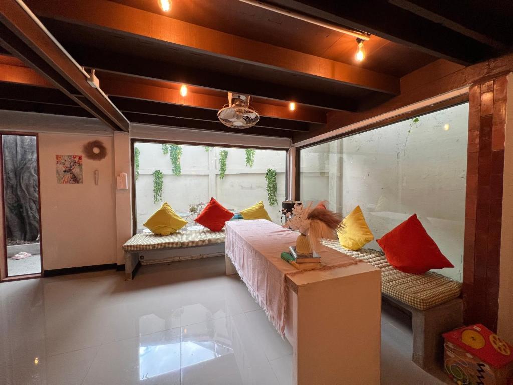 a room with a bed with colorful pillows on it at 77 Old Town in Bangkok