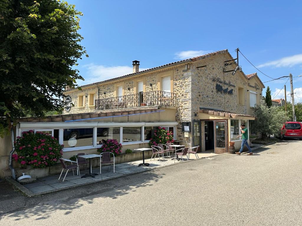 a building with tables and chairs in front of it at Le relais saint germain in Saint-Germain