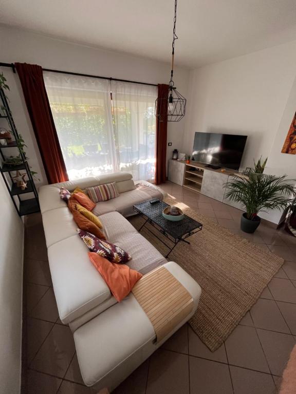 Piko's apartments في إيزولا: غرفة معيشة مع أريكة بيضاء مع وسائد عليها