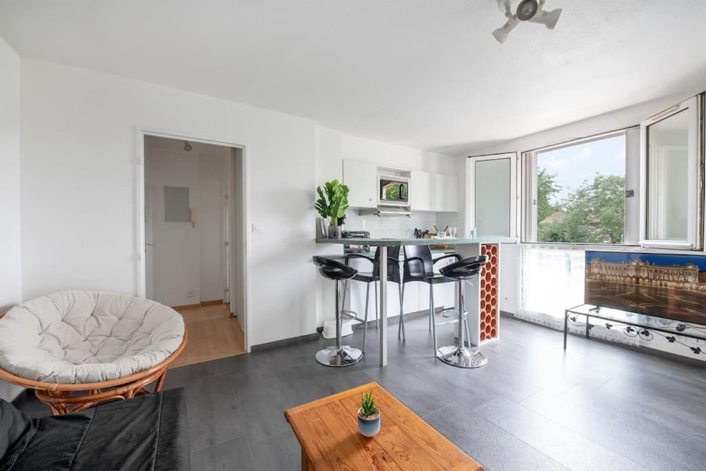 een keuken en een woonkamer met een tafel en stoelen bij T2 Rangueil - Terrasse + 2 Parkings - 4 personnes in Toulouse