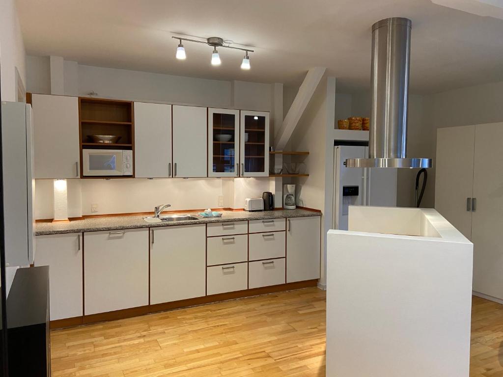 a kitchen with white cabinets and a white refrigerator at City Center Apartments 187 in Copenhagen