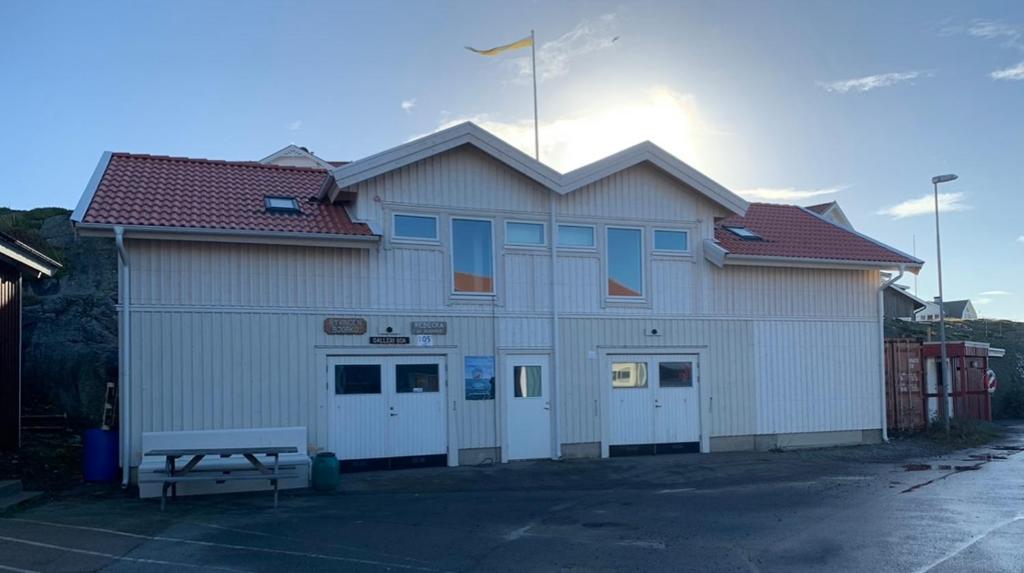 un gran edificio blanco con un banco delante en Hamnhuset Björkö, en Björkö