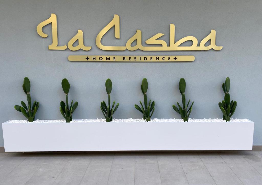um sinal para uma residência com plantas sobre uma mesa em La Casba em Paola