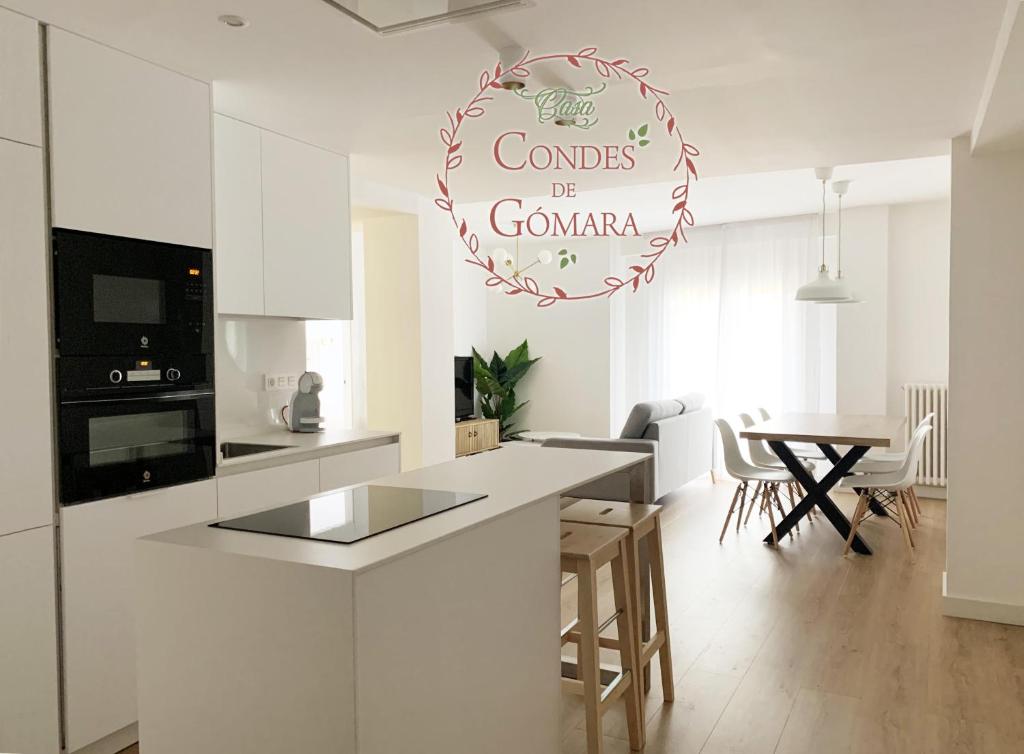 a white kitchen with a table and a sign that reads combos be german at Casa Condes de Gómara in Soria