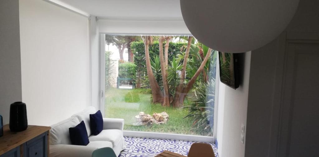 sala de estar con sofá blanco y ventana en Villa Turchina, en Porto Cesareo