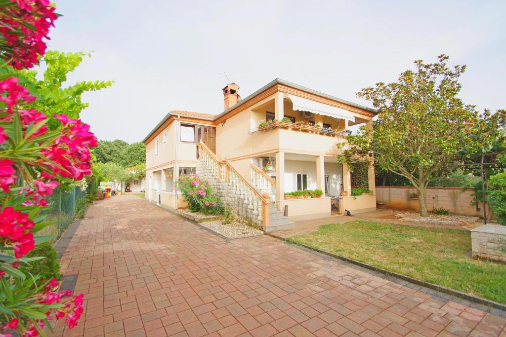 a house with a brick driveway in front of it at Apartment Pineta in village Valbandon in Valbandon