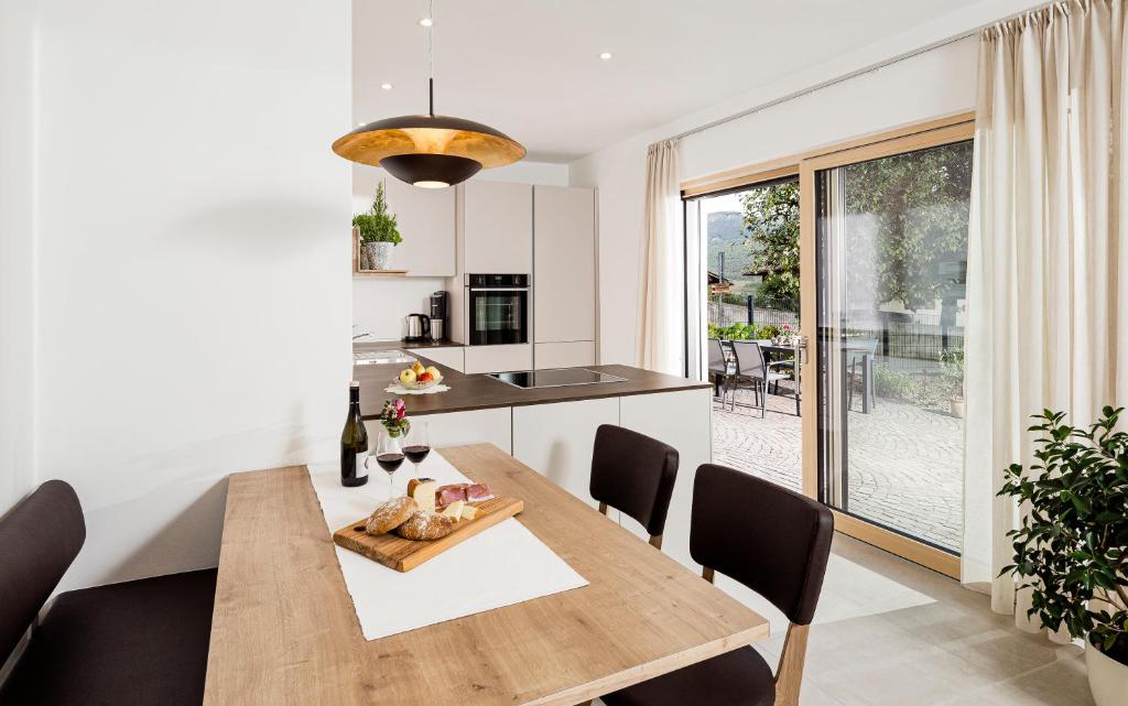 cocina y comedor con mesa de madera y sillas en Appartement Irene, en Caldaro