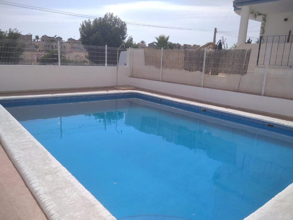 una piscina de agua azul en una casa en Homely Apartments Blue Coast, en San Miguel de Salinas