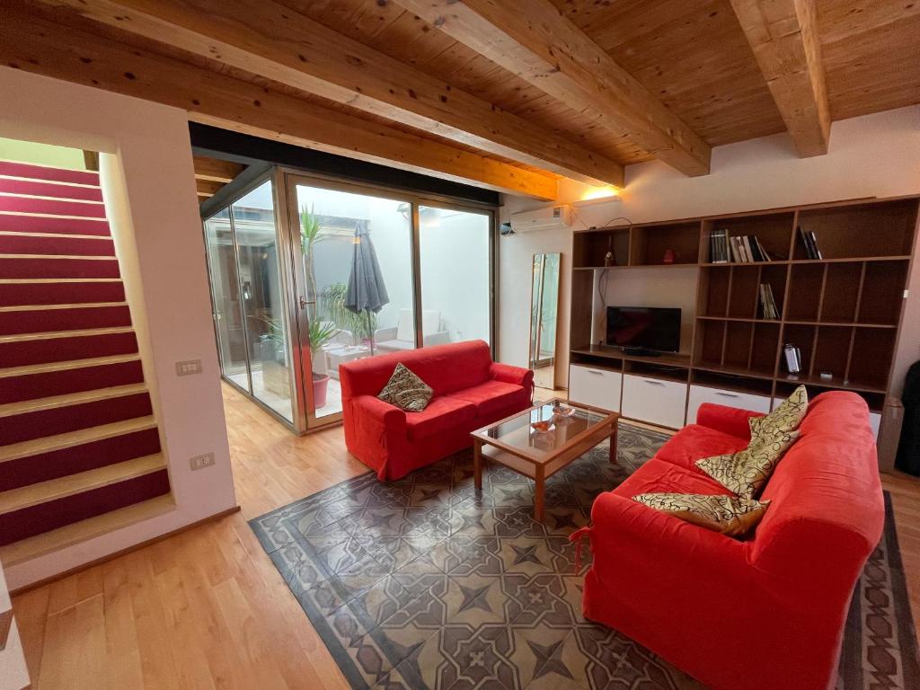 una sala de estar con 2 sofás rojos y una mesa. en Domo Is Solus en SantʼAntìoco