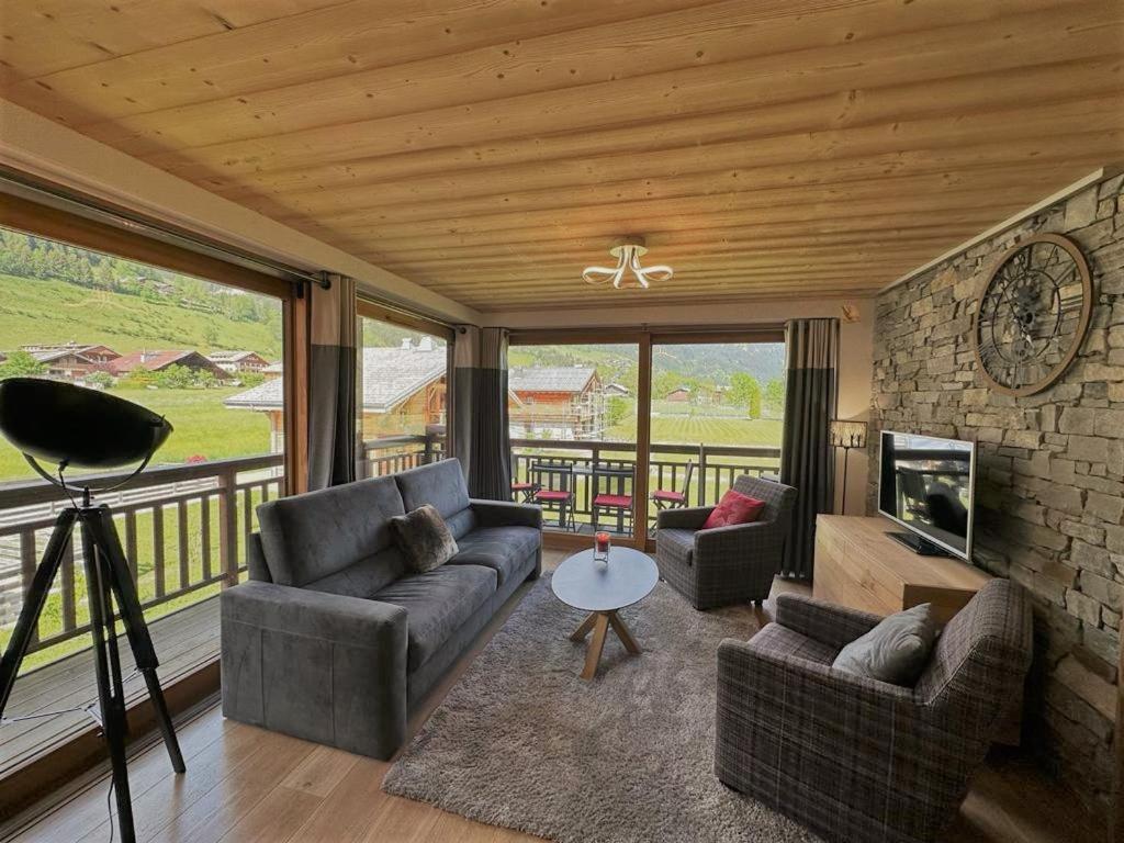 un salon avec deux canapés et une cheminée dans l'établissement Oasis - APT A07 - BO IMMOBILIER- Châtel - Multipass été en option à 3e par jour et par personne, à La Chapelle-dʼAbondance