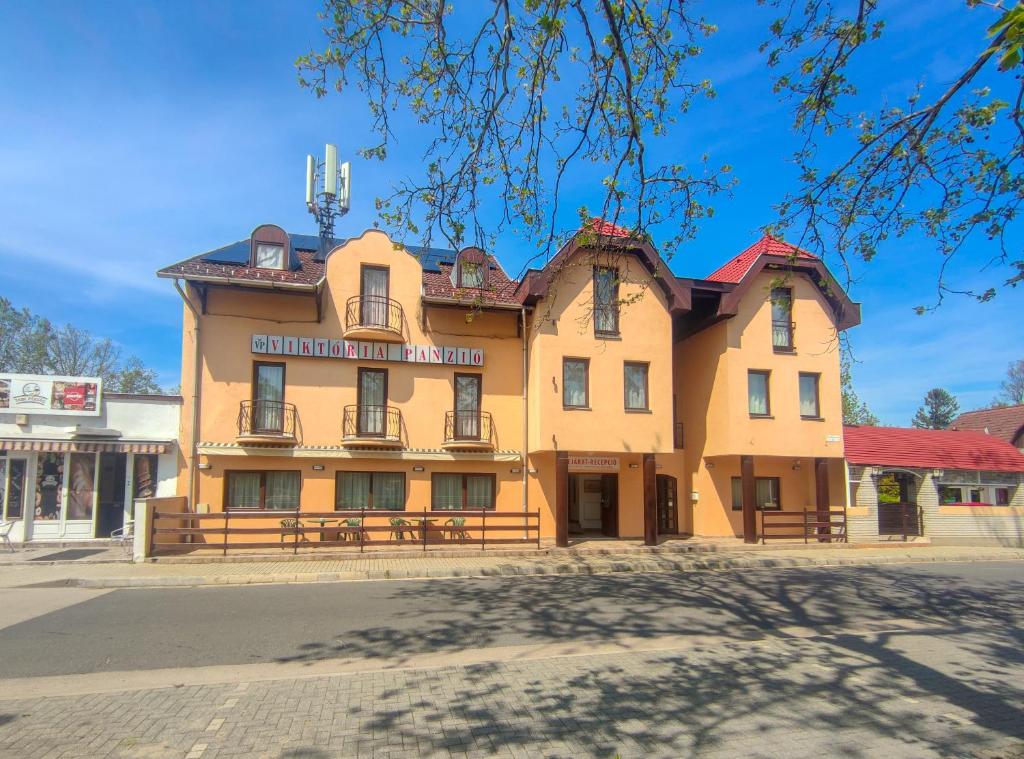 a large yellow building on the side of a street at Viktória Panzió Zamárdi in Zamárdi