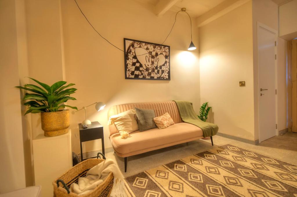 een woonkamer met een bank en een plant bij Chic duplex maisonette in Valletta centre-DDEM4 in Valletta