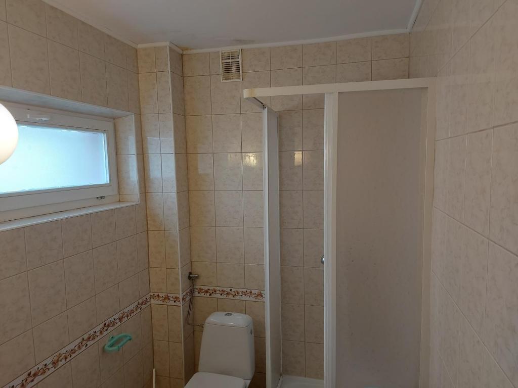 a bathroom with a white toilet and a window at Pokoje Gościnne Tomasz in Międzywodzie