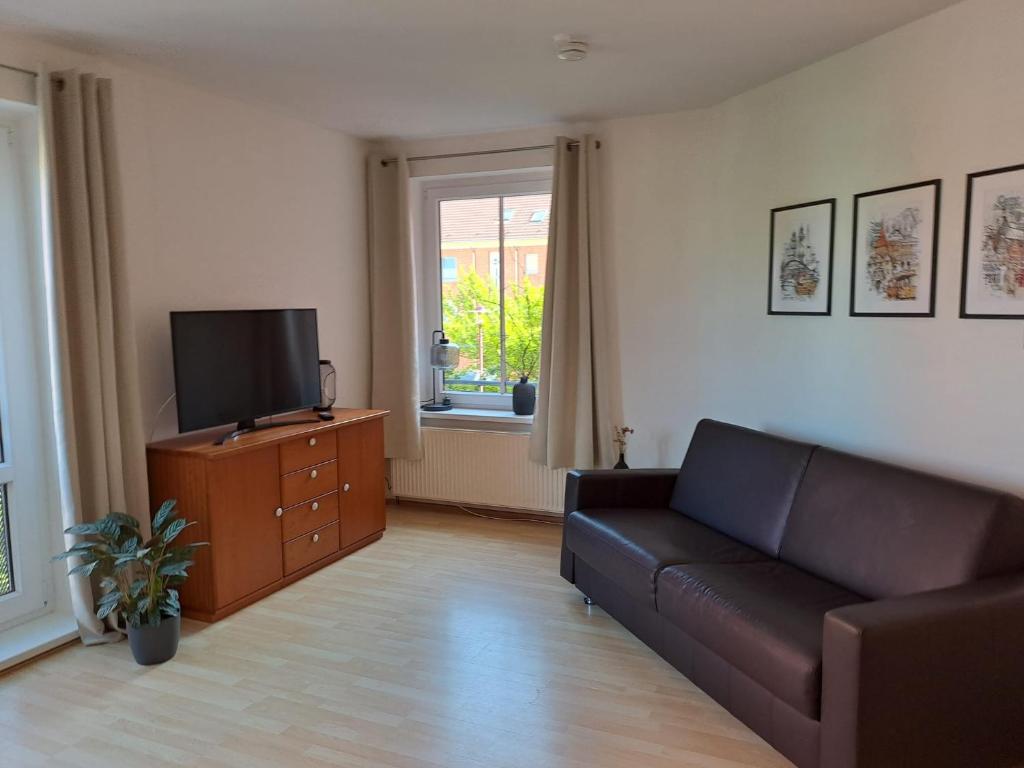 a living room with a couch and a flat screen tv at Ferienwohnung Auszeit in Rostock