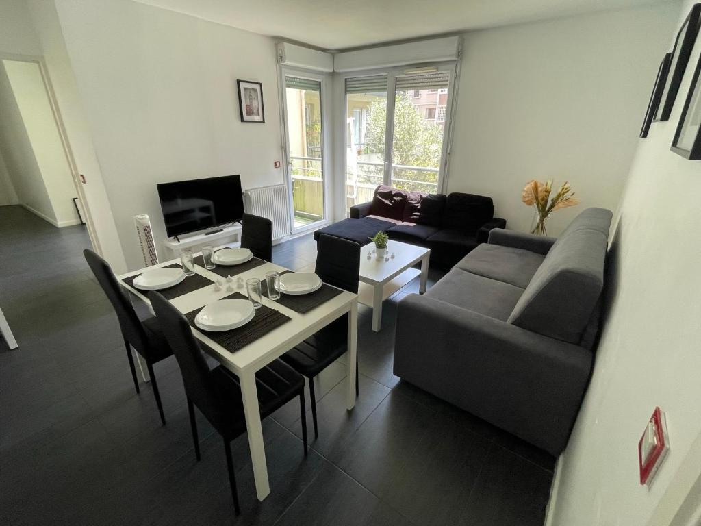 a living room with a table and a couch at T5 4 chambres Gratte ciel, Villeurbanne, meublé in Villeurbanne