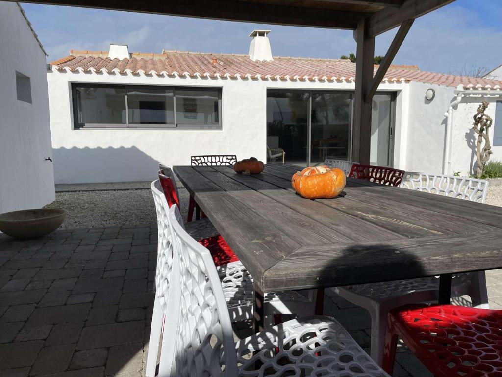 une table en bois avec une citrouille sur une terrasse dans l'établissement Maison en bord de mer à Noirmoutier : 3 chambres, jardin clos, internet, parking, plage à 250m - FR-1-224B-646, à Noirmoutier-en-l'lle