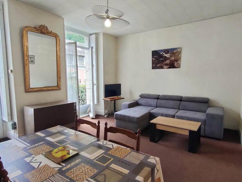 un salon avec un canapé et une table dans l'établissement Appartement 2 pièces central à Cauterets avec balcon, parking et proximité Citycab - FR-1-234-145, à Cauterets
