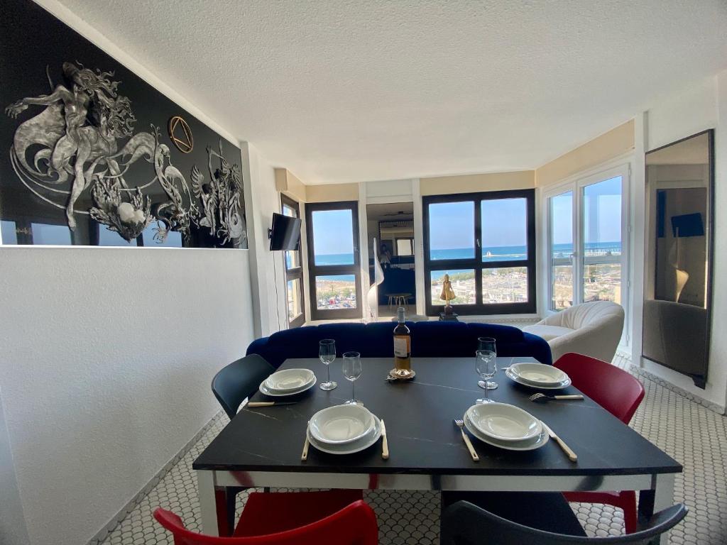 comedor con mesa y sillas con vistas en Le Mousse, P2 cosy avec une magnifique vue mer, parking, en La Grande-Motte