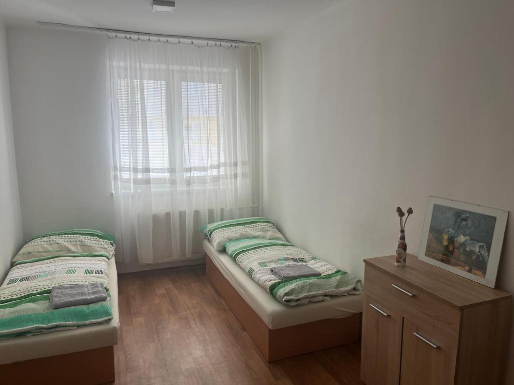 1 dormitorio con 2 camas individuales y ventana en Danubius Szálló, en Komárno