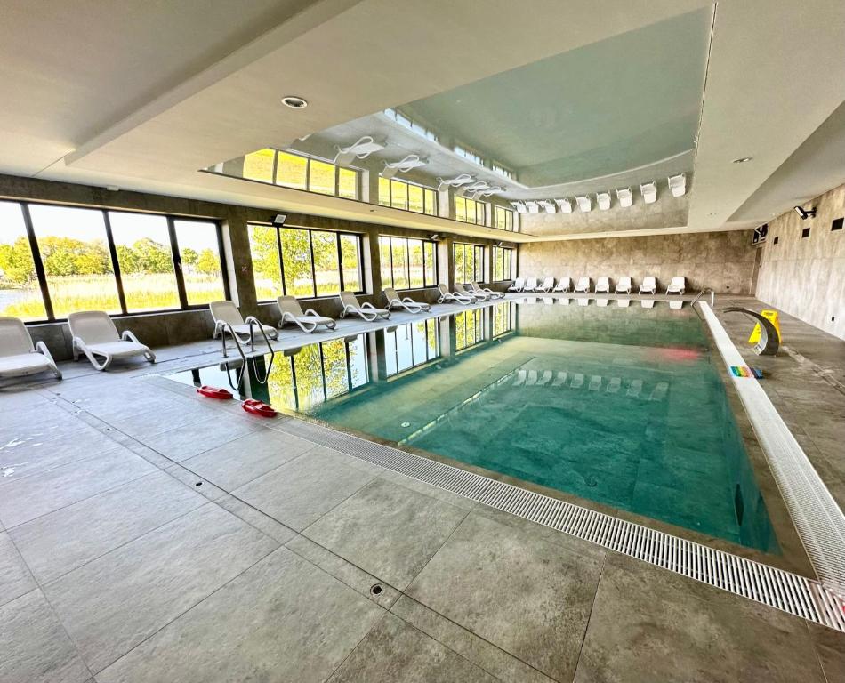 una grande piscina coperta con sedie in un edificio di La Riva Mia Spa Dziwnów a Dziwnów