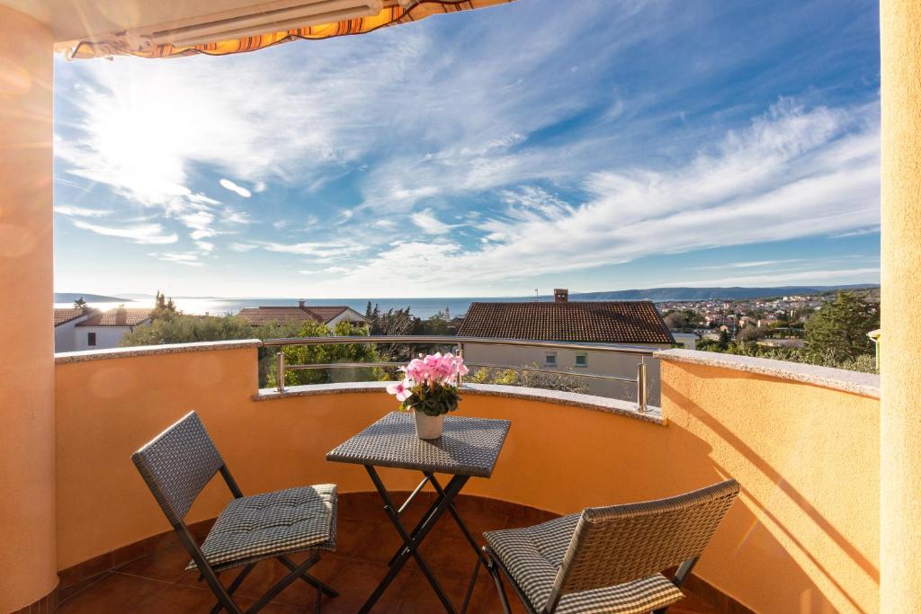 eine Terrasse mit einem Tisch und Stühlen auf dem Balkon in der Unterkunft Apartments Bella Vista in Krk