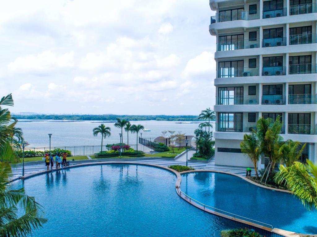 a large swimming pool next to a tall building at Scenic Country Garden Danga Bay by Lions Bay in Johor Bahru