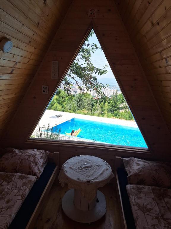 een kamer met een raam en uitzicht op een zwembad bij Bungalovi Lana in Sarajevo